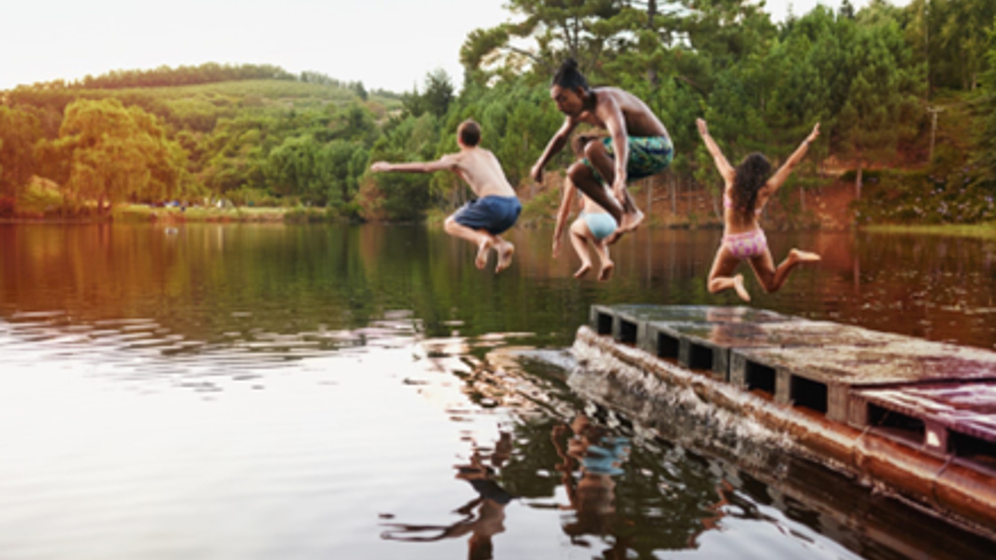 Boys and girls at camp going for a dip off the dock