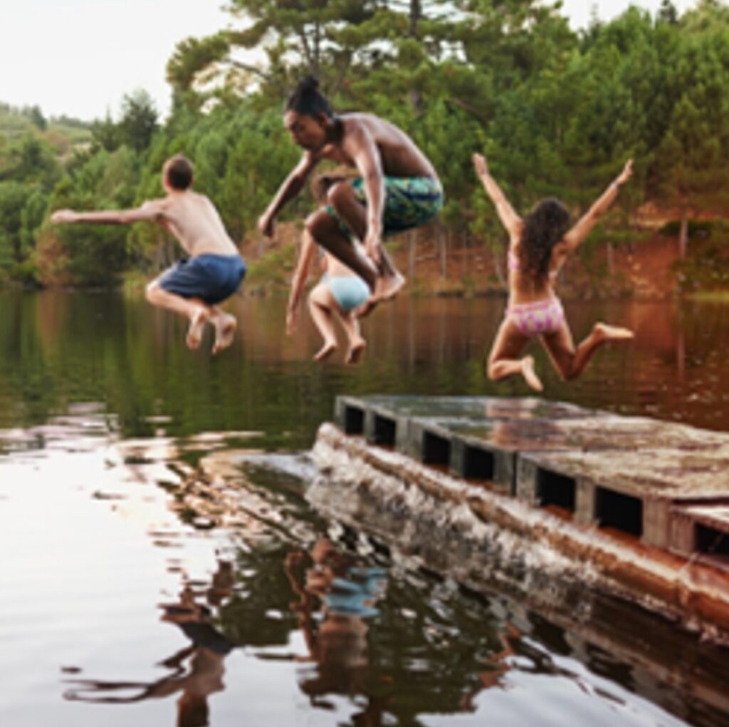 Boys and girls at camp going for a dip off the dock