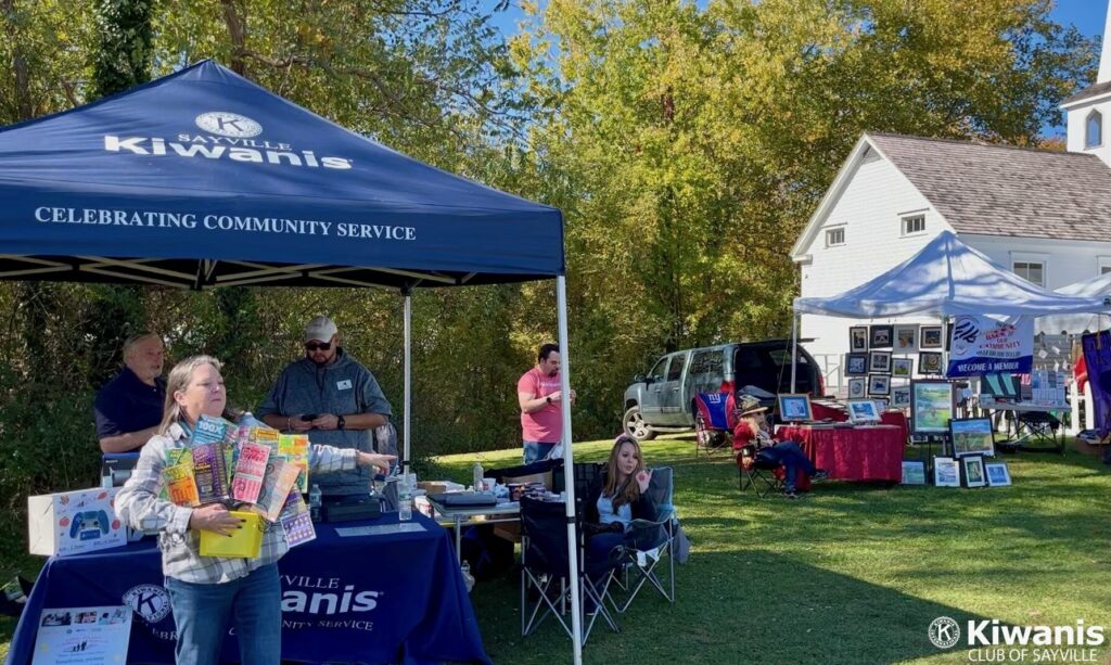 The Kiwanis of Sayville booth at Apple Fest 2022 with Kiwanis of Sayville member Alesia Olsen in the foreground