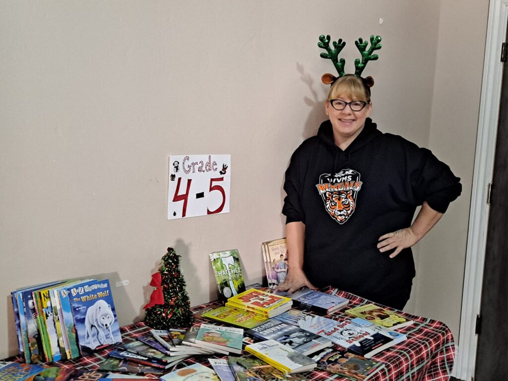 Erin Burchett at Toys for Joy. Keeping the tables stocked with books for families to choose from. Dec 2023