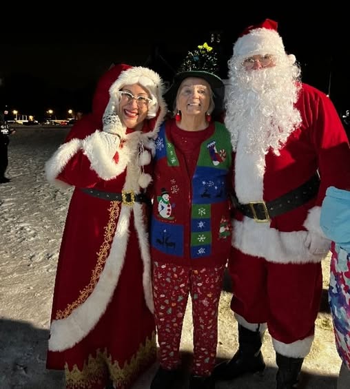 Club member, Judy, had a blast serving hot chocolate and cookies but took a moment to pose with Santa & Mrs. Claus.