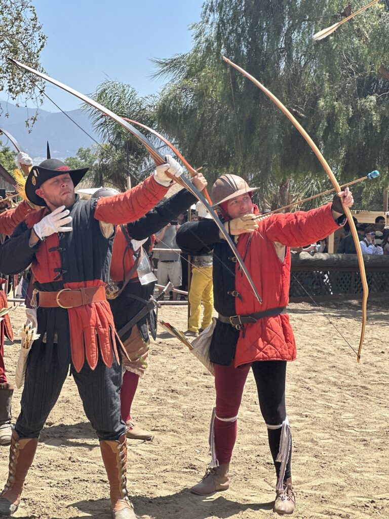 Two archers in red drawing longbows