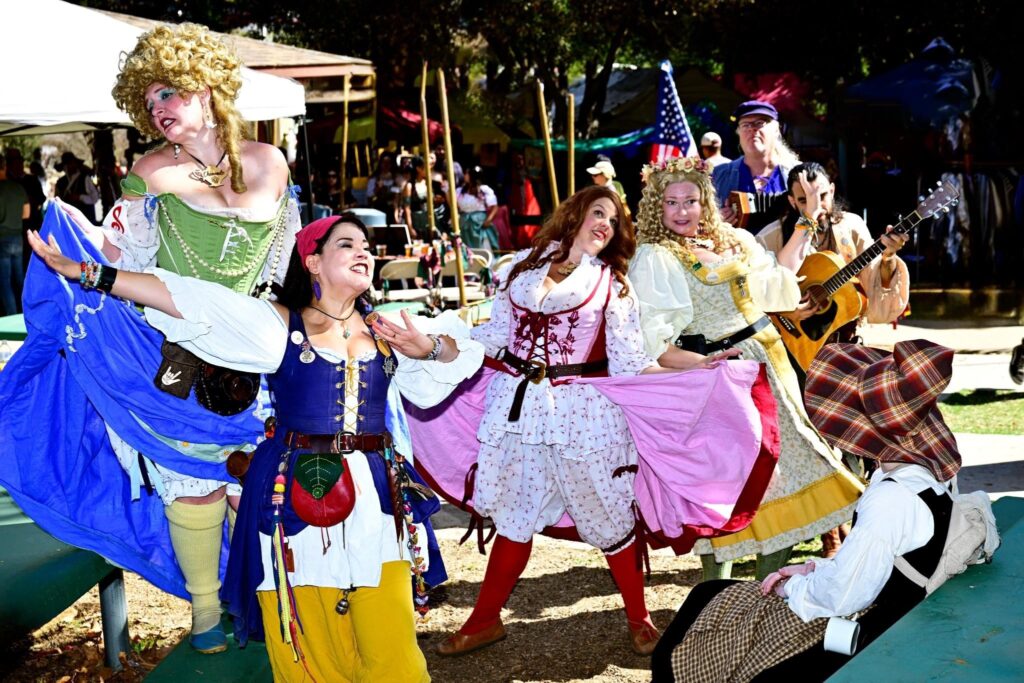 Five costumed dancers performing on stage at the Santee fair