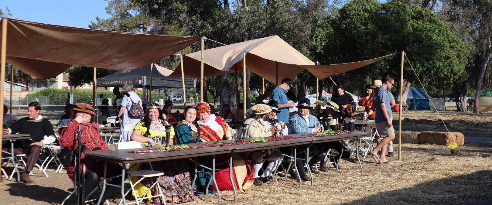 Guests in costume at the long Queen's Feast tables