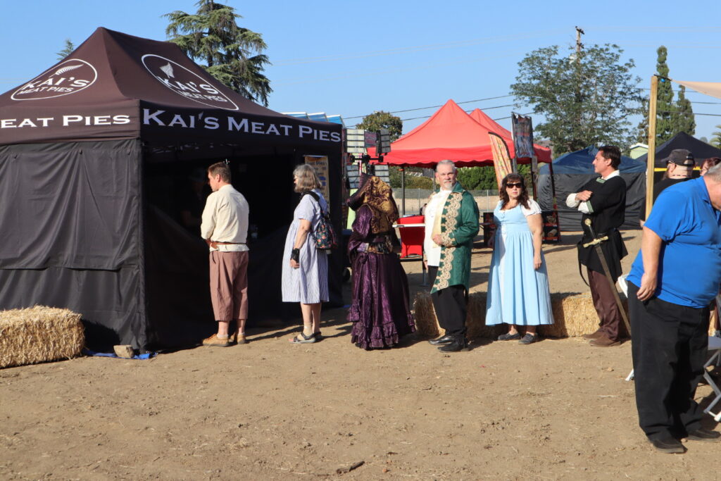 Costumed guests outside the Kai's Meat Pies booth