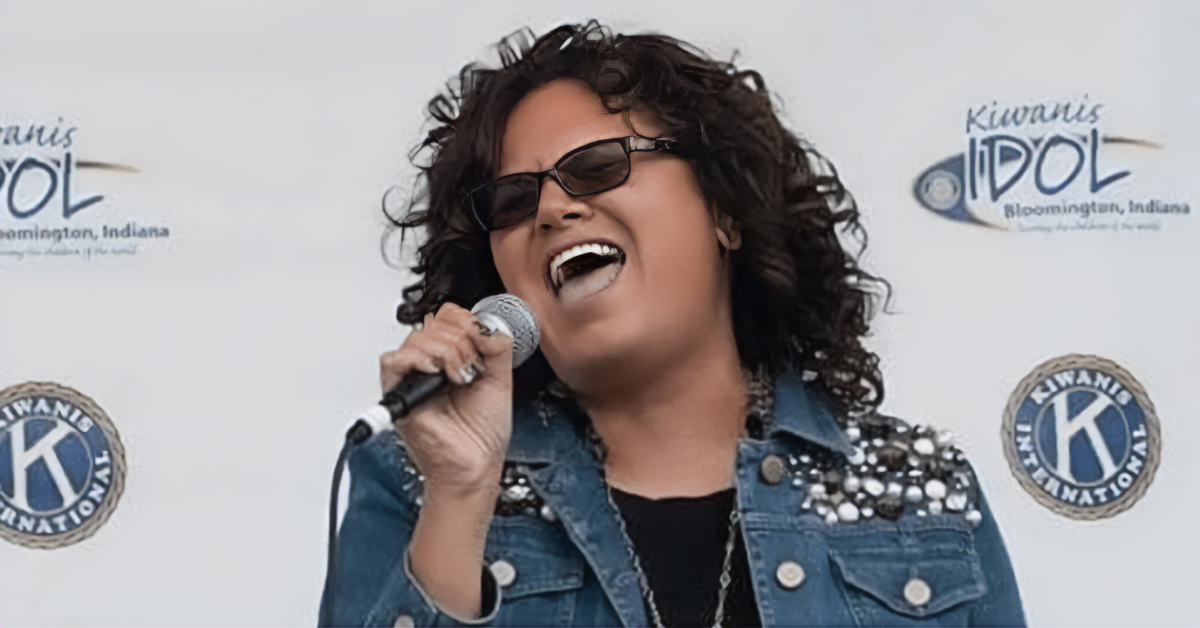 Singer performing on stage during the SCI Kiwanis Idol singing competition in Bloomington, Indiana, supporting community programs for children.