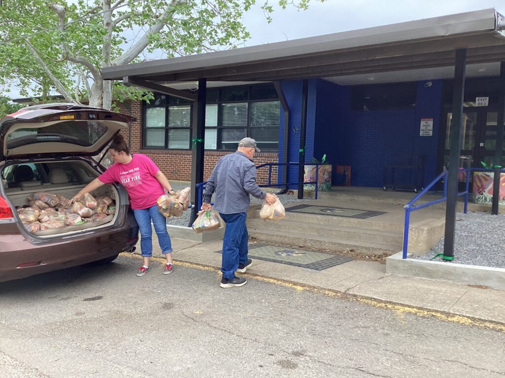 Kiwanis members delivering Meals for At Risk Kids to the Elementary School with the assistance of school staff.