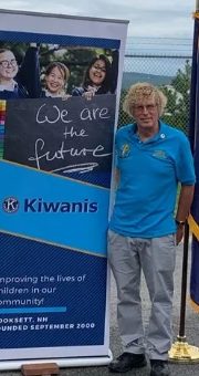 Club President Bob Willey standing beside a blue Kiwanis banner that reads &ldquo;We are the future.&rdquo;