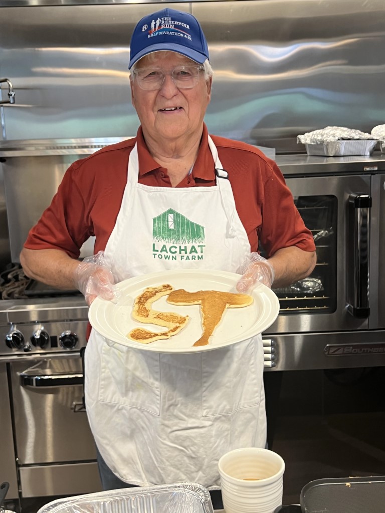 Steve Thomas holding a plate with pancakes in the form of his initials.