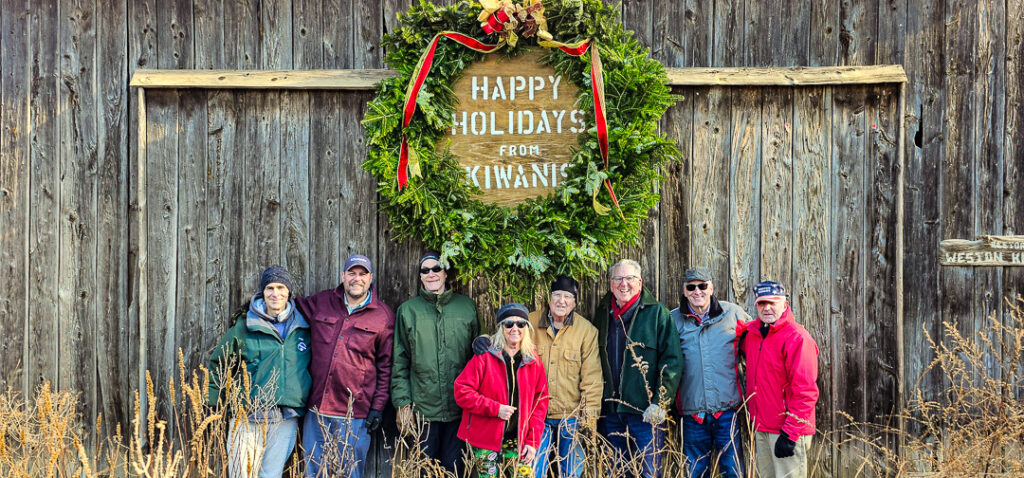 Kiwanis wreath and members in front of onion barn.