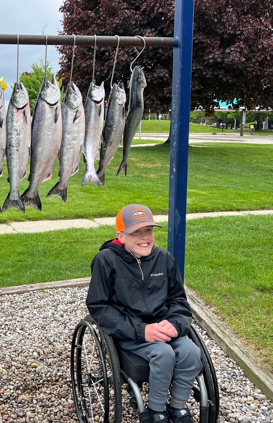 Boy in wheelchair poses with fish