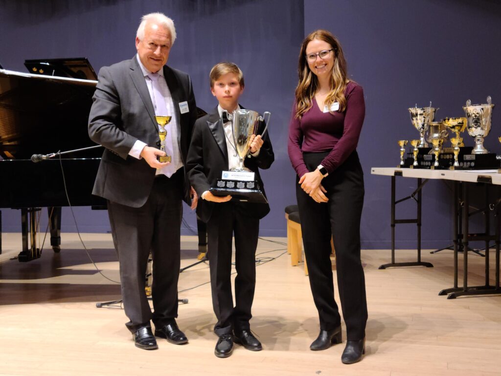 Trophy presentation to a young winner of piano performance at the Kiwanis Music Festival in Waterloo.