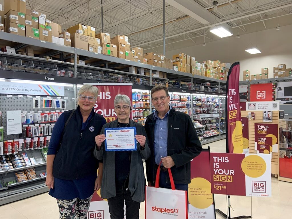 Club officers pose with the manager of Staples to celebrate the project which provides school supply vouchers for elementary students in the Waterloo Region.