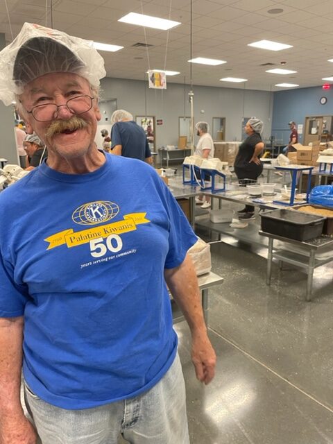 Man wearing head bonnet during food packing event at Feed My Starving Children