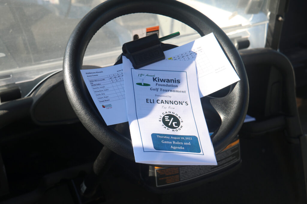 Tournament brochure placed on the golf cart wheel in preparation for the golf tournament.