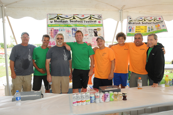 Members stand in from of a table at the Montauk Seafood Festival.